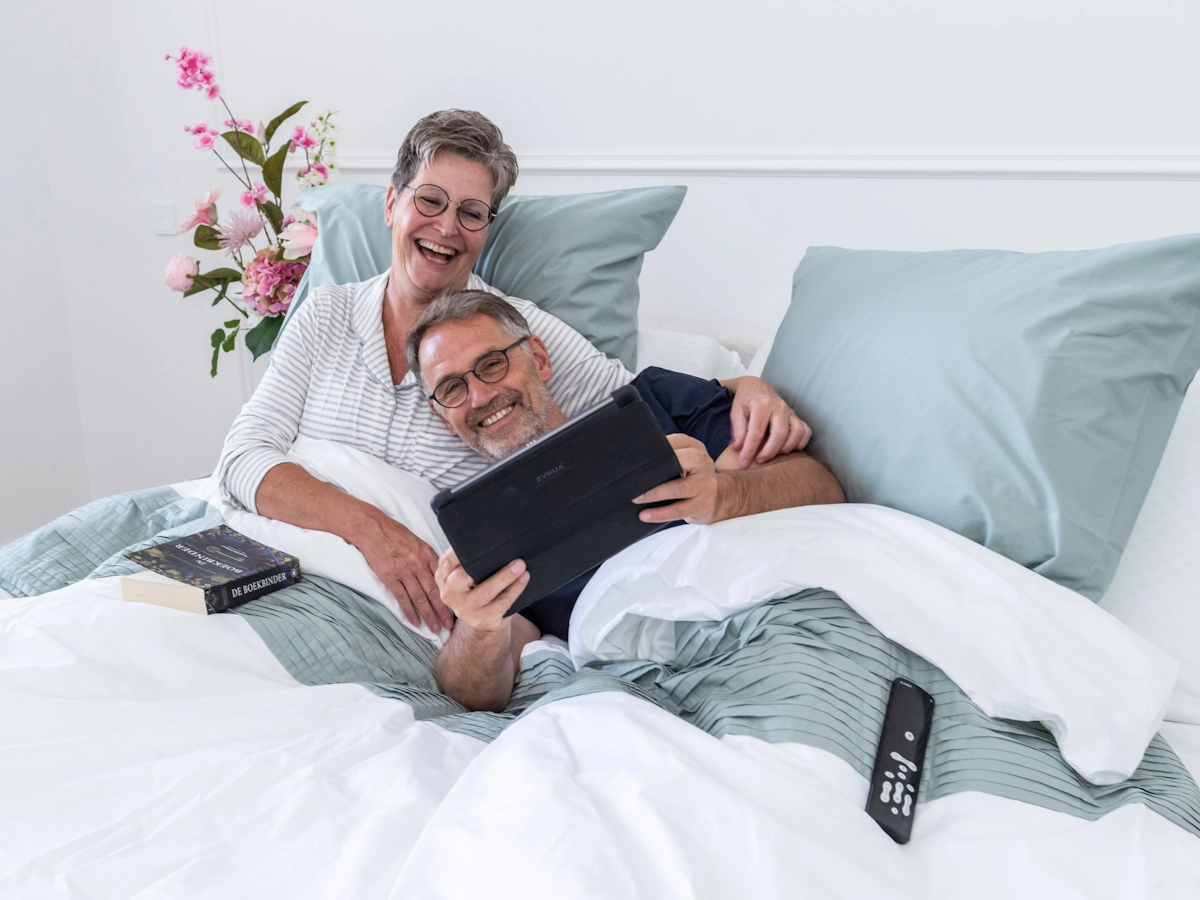 Twee ouderen liggen samen in een seniorenbed